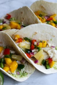 These Fish Tacos with Pineapple Mango Salsa are an easy and flavorful dish for the summer!