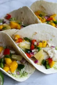 These Fish Tacos with Pineapple Mango Salsa are an easy and flavorful dish for the summer!