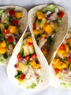 These Fish Tacos with Pineapple Mango Salsa are an easy and flavorful dish for the summer!