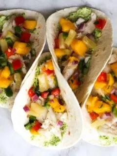 These Fish Tacos with Pineapple Mango Salsa are an easy and flavorful dish for the summer!