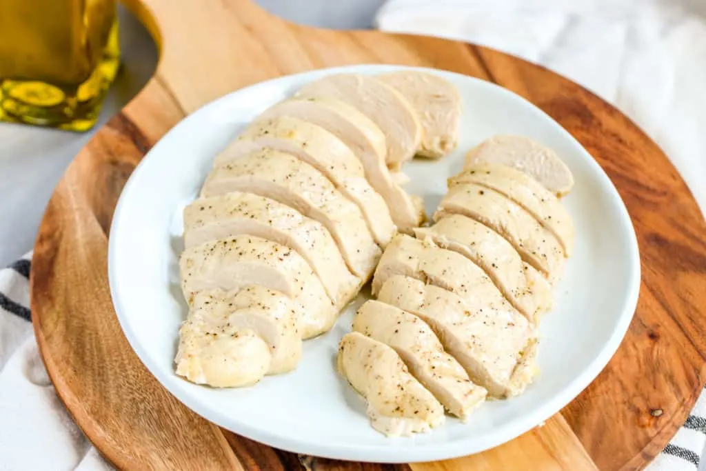 two sliced chicken breasts on a white plate