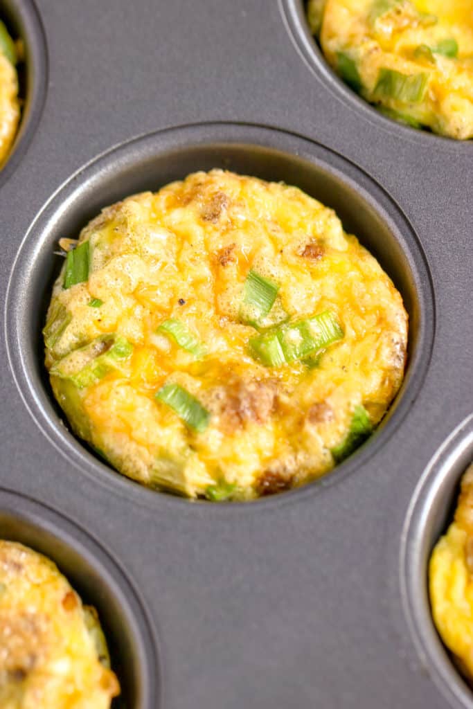 a close up shot of an egg muffin in the muffin tin