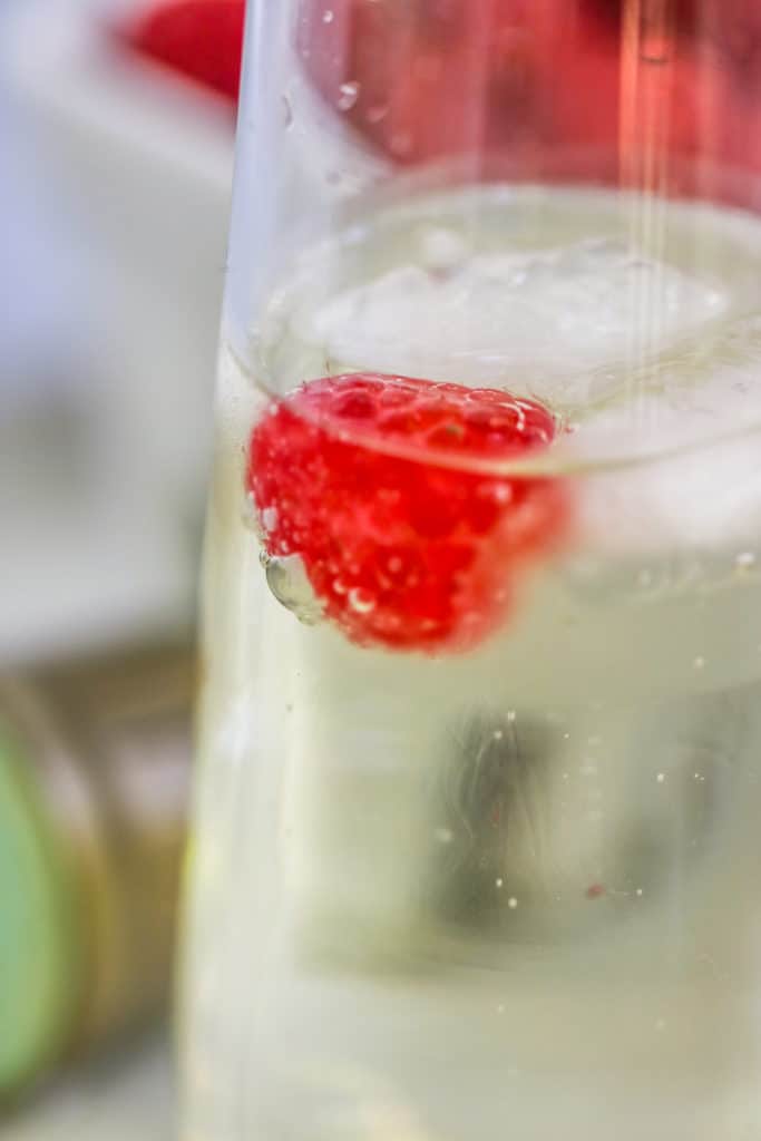 a closeup of a raspberry in a champagne flute