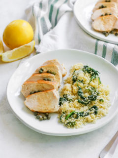 an angle image looking at the white plate of lemon caper chicken