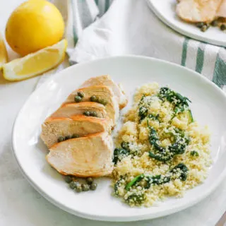 an angle image looking at the white plate of lemon caper chicken