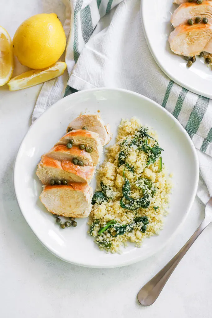 looking above the plate of lemon caper chicken with lemons on the side