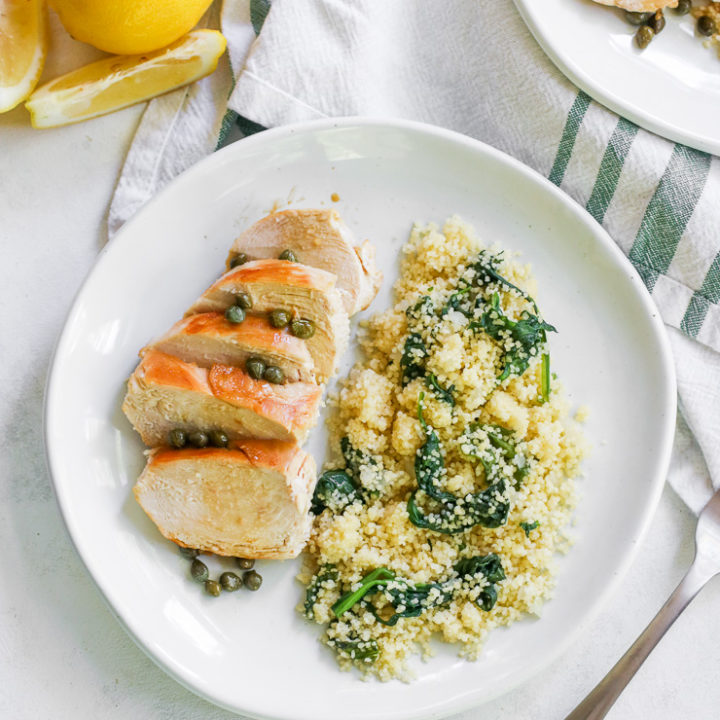 looking above the plate of lemon caper chicken with lemons on the side