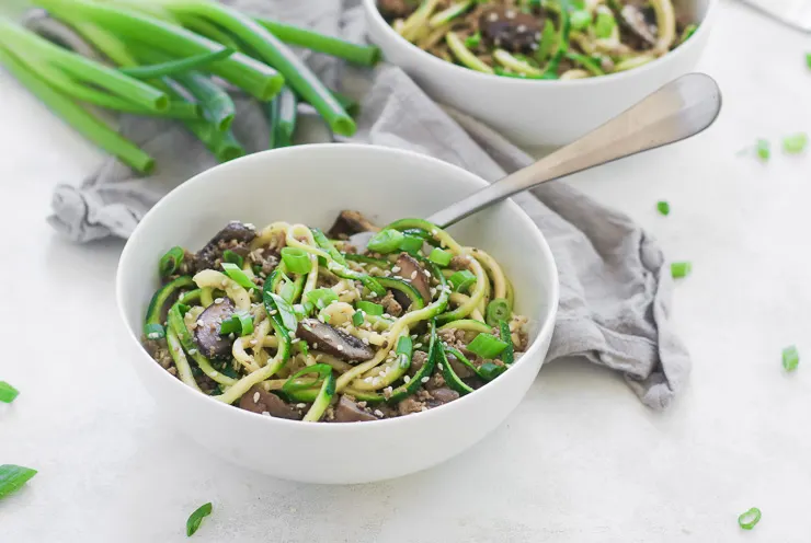 a white bowl of sesame zoodles with ground turkey