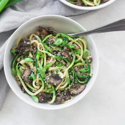 an over head shot of a bowl with sesame zoodles and a fork