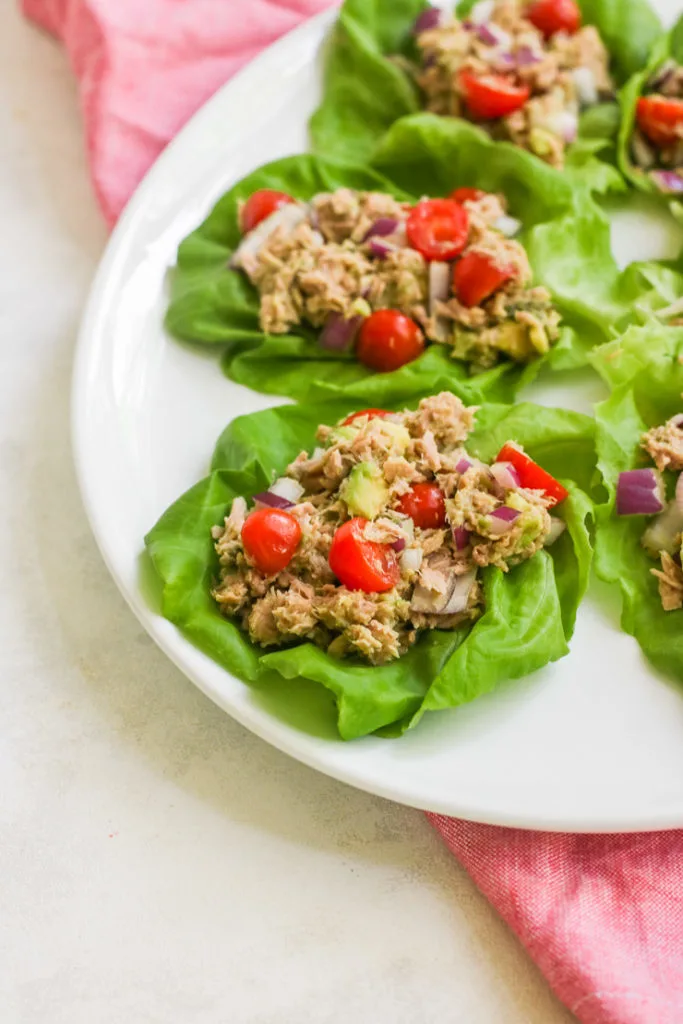 a close up of the two tuna avocado lettuce wraps on the edge of the platter
