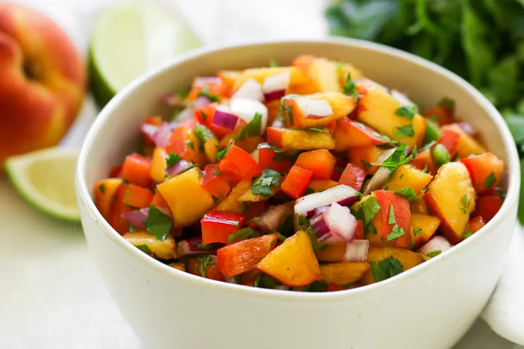 chopped peached, red onion, peppers, and cilantro in a bowl