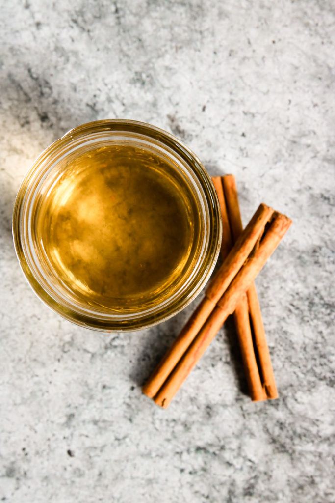 an overhead shot of simple syrup and cinnamon sticks