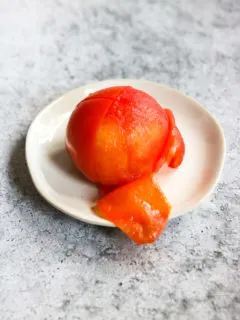 a half peeled tomato on a small plate