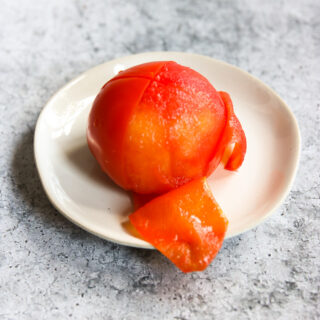 a half peeled tomato on a small plate
