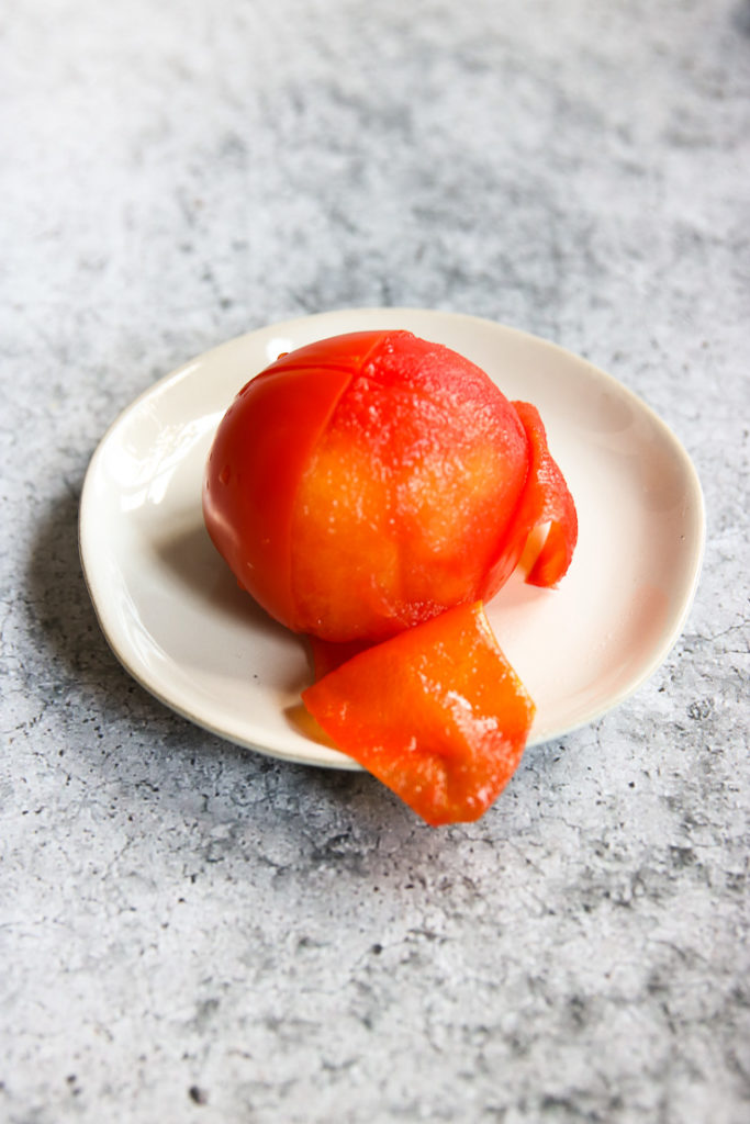 a half peeled tomato on a small plate