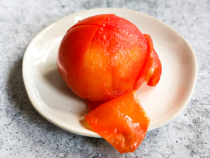 a half peeled tomato on a small plate