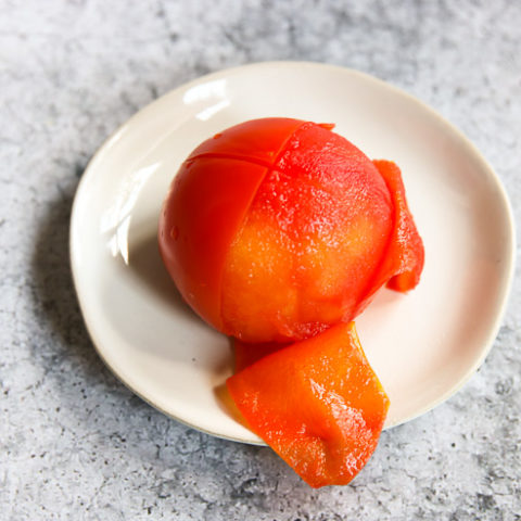 a half peeled tomato on a plate