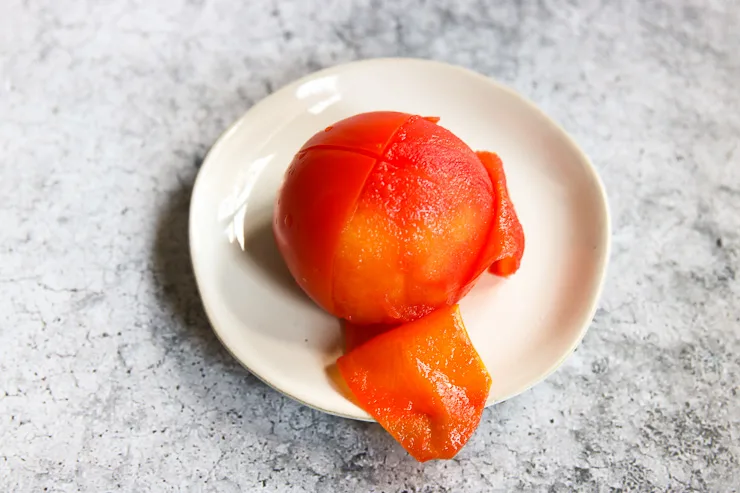 a half peeled tomato on a plate