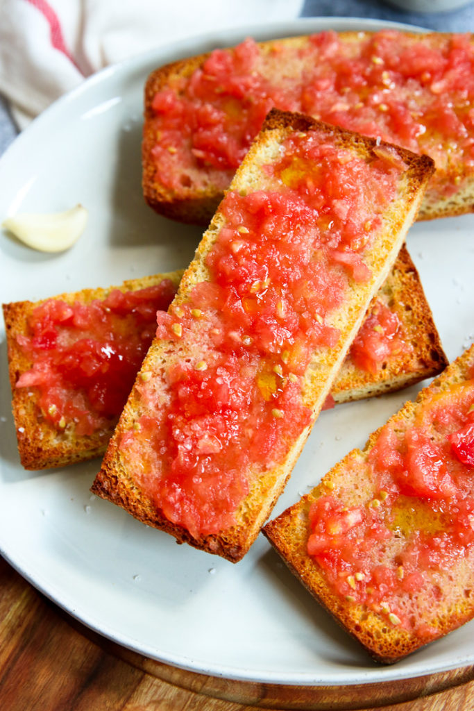 a slice of toasted bread with a grated tomato mixture