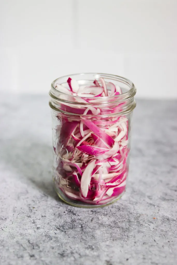 a mason jar of raw red onions