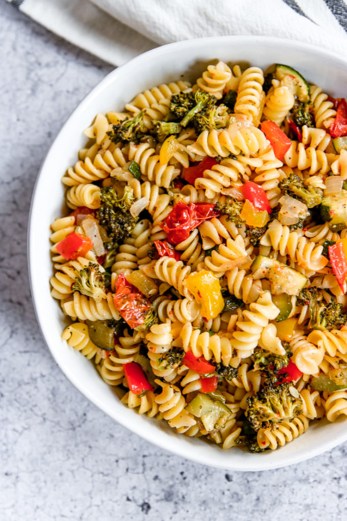 a close up of roasted vegetable pasta in a large white bowl