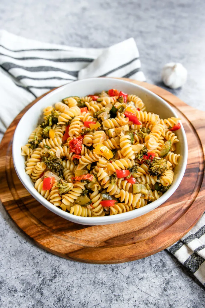 a white bowl full of roasted vegetable pasta