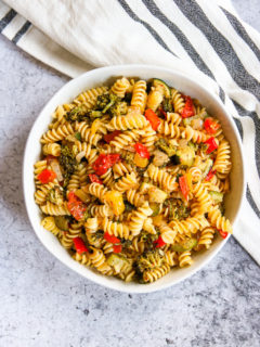 an overhead shot of a white bowl of roasted vegetable pasta