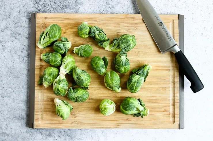 a cutting board full of brussels sprouts