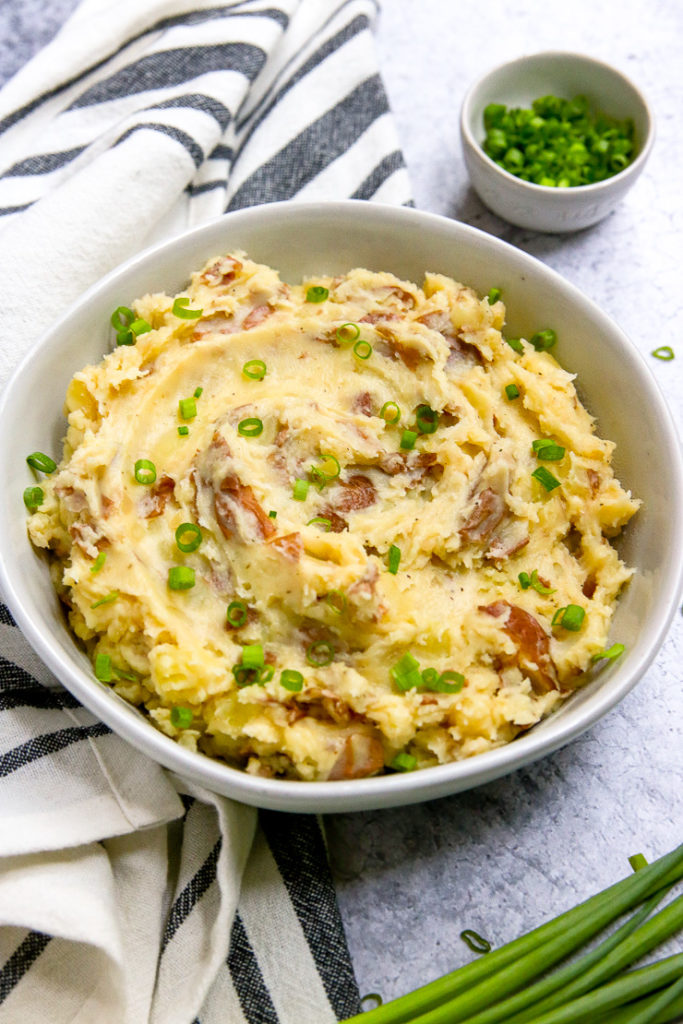 a bowl of red skin mashed potatoes with green onions