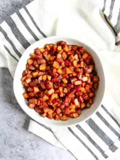 An overhead shot of a white bowl filled with Skillet Breakfast Potatoes