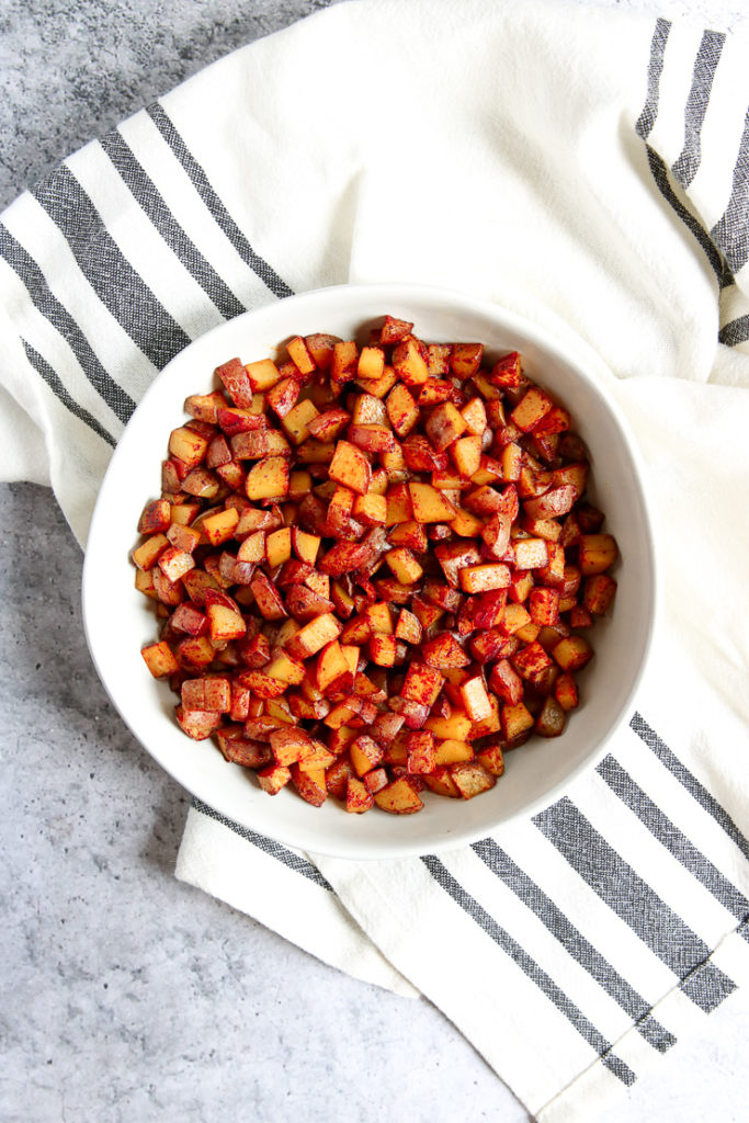 An overhead shot of a white bowl filled with Skillet Breakfast Potatoes