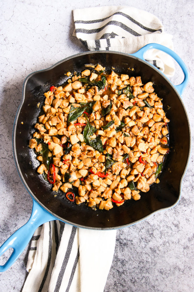 a blue cast iron skillet of thai basil chicken