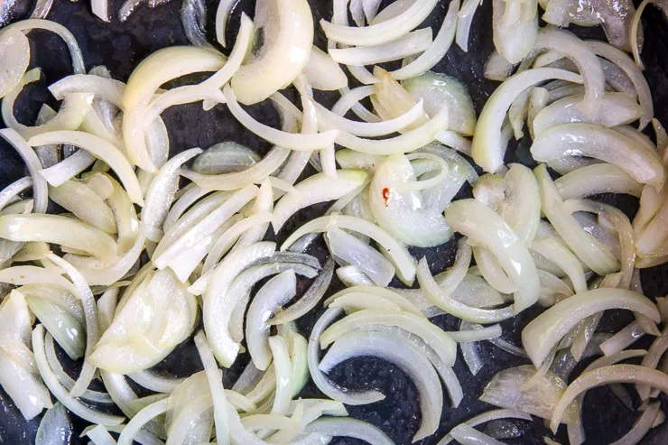 close up of sliced onions getting sauteed in a pan