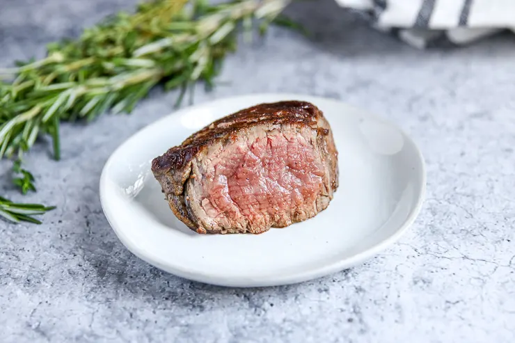 a sliced piece of filet mignon showing a light pink center