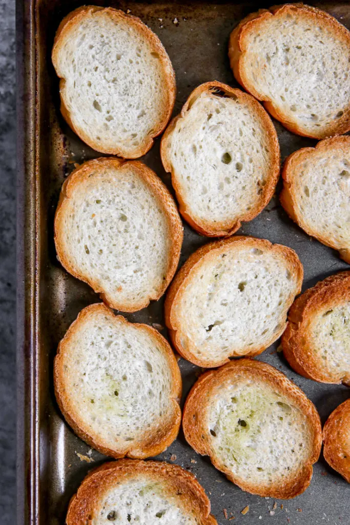 a close up of toasted slices of bread on a cookie sheet