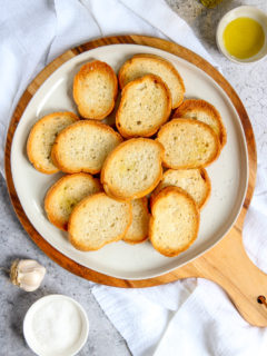 an overhead shot of toasted crostini with olive oil, garlic, and salt