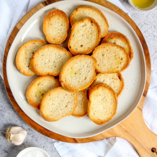an overhead shot of toasted crostini with olive oil, garlic, and salt
