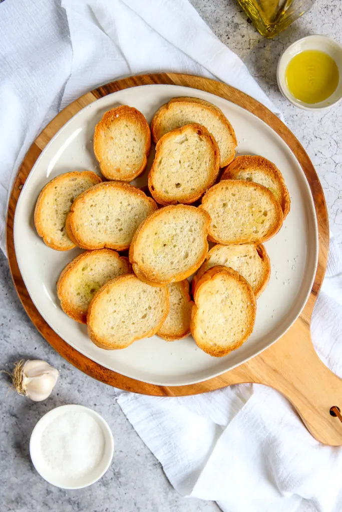 an overhead shot of toasted crostini with olive oil, garlic, and salt