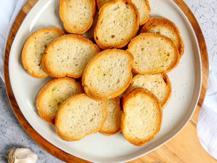 an overhead shot of toasted crostini with olive oil, garlic, and salt