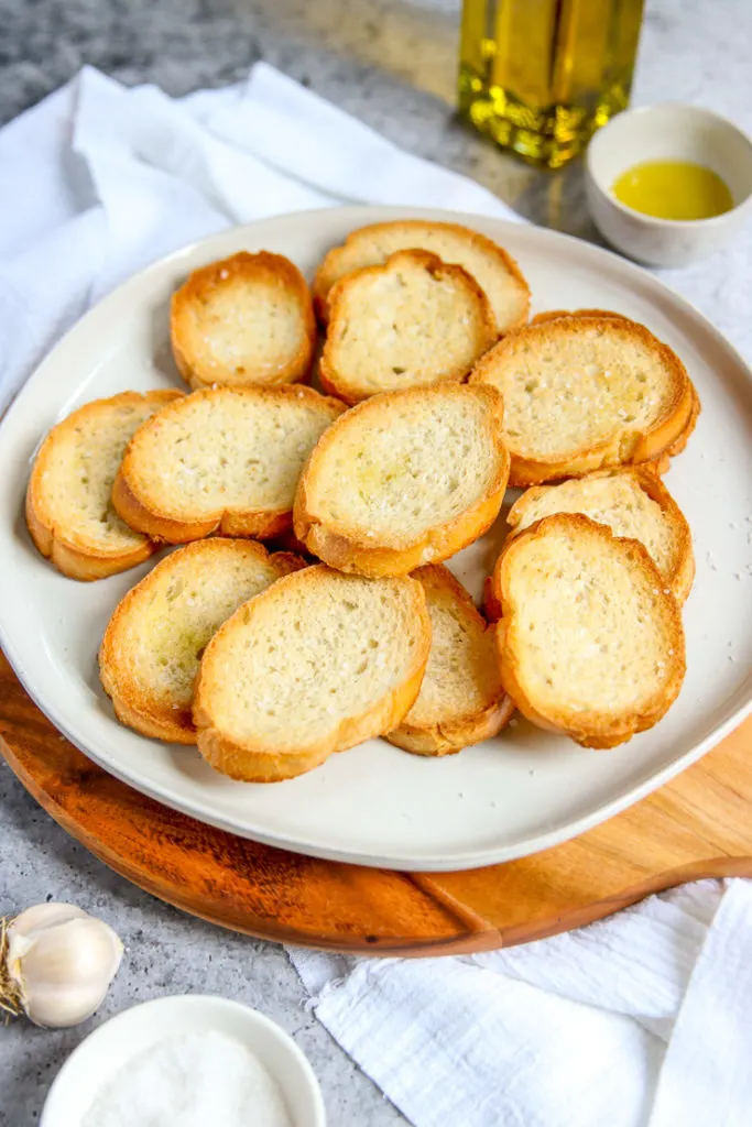 a close up of toasted crostini with olive oil in the background