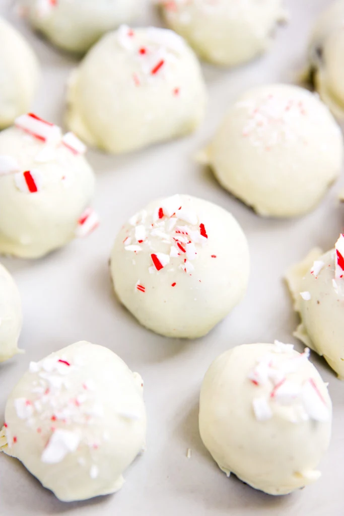 a close up of one peppermint oreo truffle covered in crushed candy canes