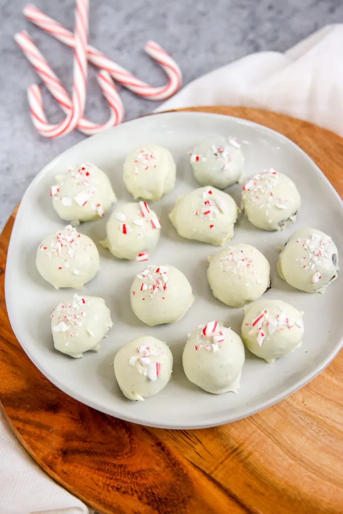 a plate of peppermint oreo truffles on a wooden platter