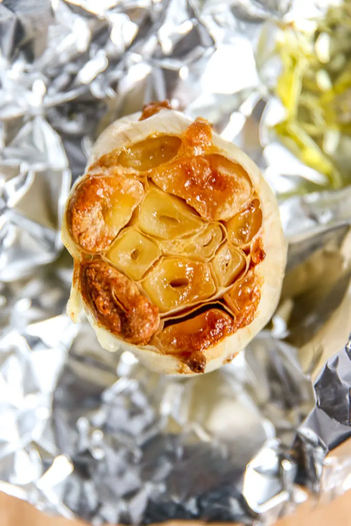 a close up of roasted garlic in aluminum foil