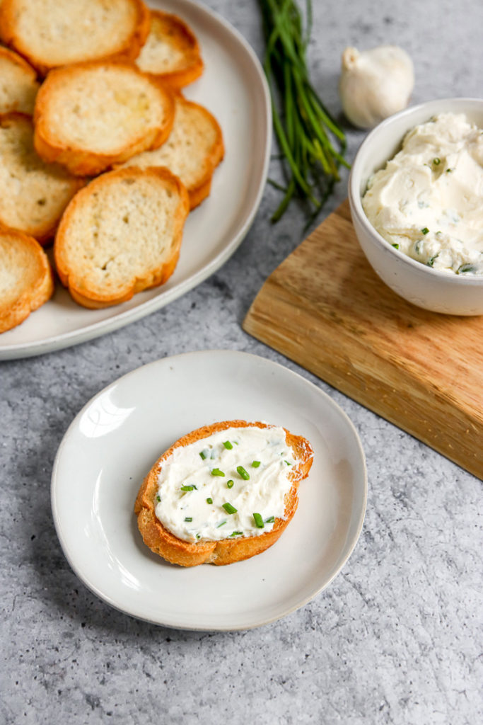 a closeup of roasted garlic spread next to crostini