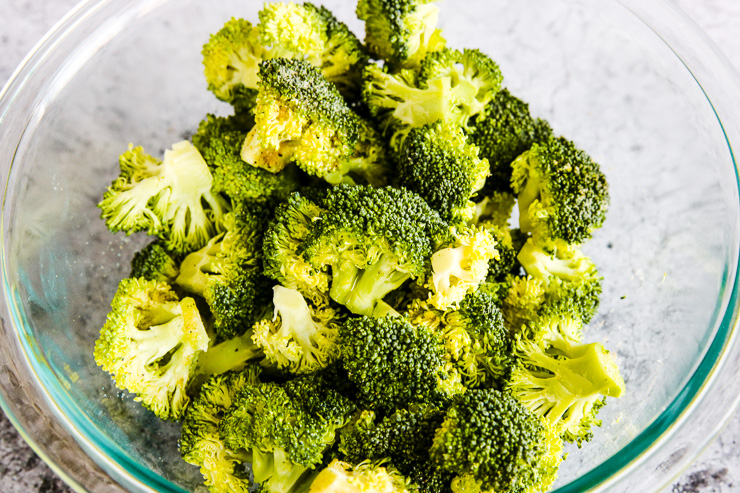 a glass bowl filled with broccoli florets