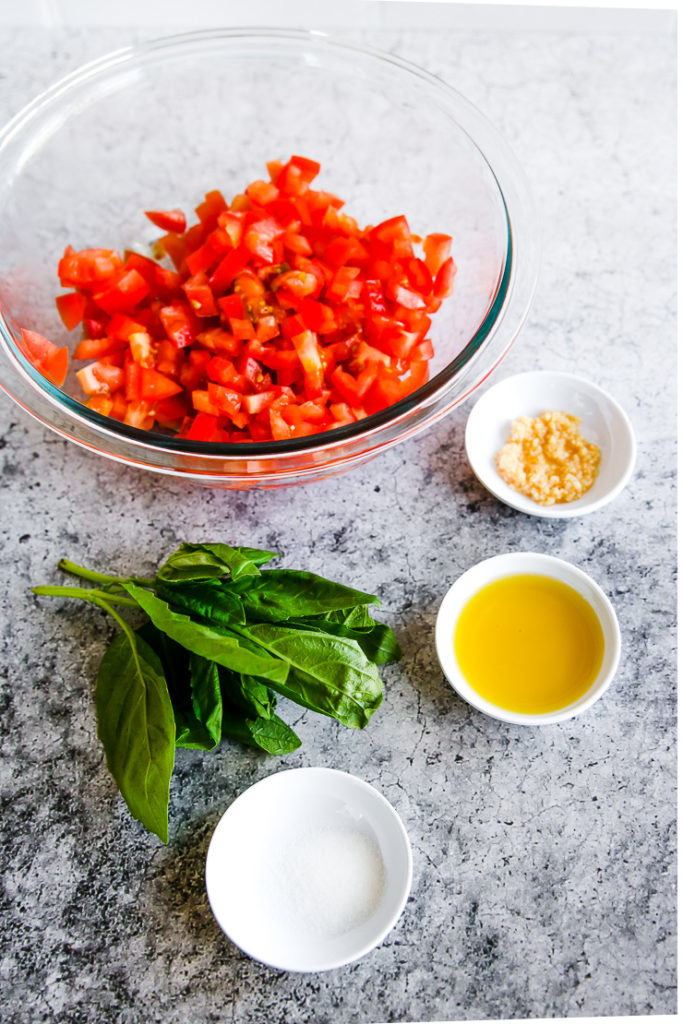 bowls of diced tomatoes, minced garlic, olive oil, salt, and a bunch of basil