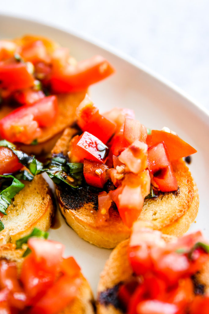 a close up of a piece of bruscetta with balsamic glaze