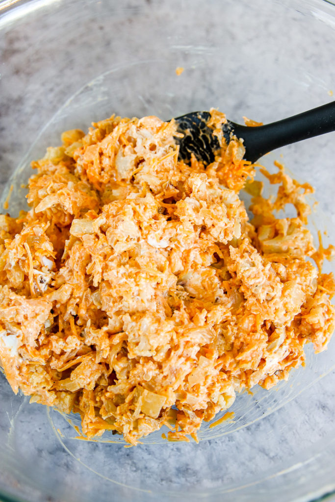 all the buffalo cauliflower dip ingredients mixed together in a glass bowl