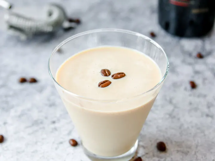 a stemless espresso martini with baileys with a bottle of baileys in the background