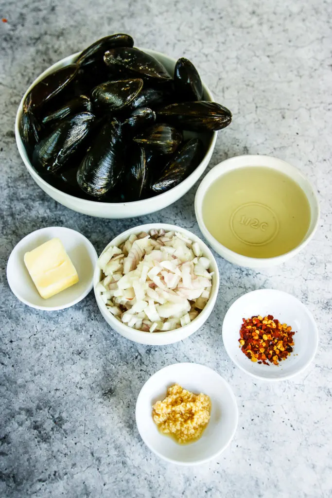 bowls of mussels, white wine, shallots, butter, red pepper flakes, and minced garlic